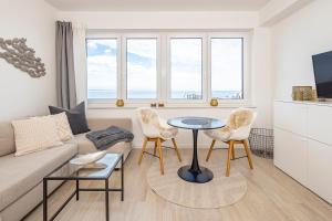 a living room with a couch and a table and chairs at Ostsee Suite 4 - Strandperle in Niendorf