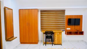 a room with a desk with a chair and a television at Eettickal Homes in Ūdumbanshola