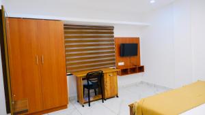 a bedroom with a desk and a bed and a television at Eettickal Homes in Ūdumbanshola