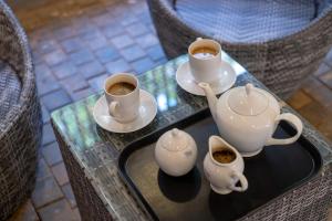 a table with two cups of coffee and saucers at Leopard Eye Resort in Kitulgala +16 photos