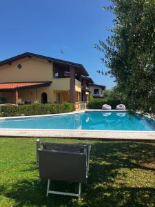 a swimming pool with a chair in front of a house at Casale el galet in Moniga