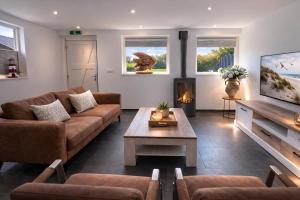 a living room with a couch and a fireplace at Ballumerhoeve Tree Lodge in Ballum