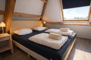 two beds in a small room with a window at Ballumerhoeve Tree Lodge in Ballum