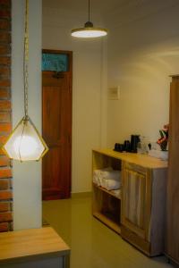 a room with a table and a light hanging from the ceiling at 3Arch Eco Cottage Ella in Ella