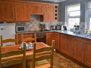 a kitchen with wooden cabinets and a wooden table with a dining room at Brada View in Bamburgh