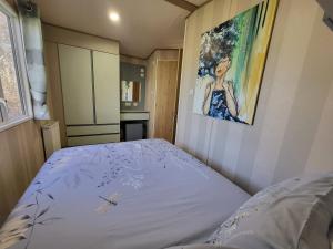 a bed in a bedroom with a painting on the wall at East Lothian Escape in Port Seton