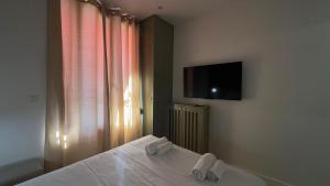a bedroom with a bed and a tv on the wall at Alma Hotel in Courbevoie +19 photos