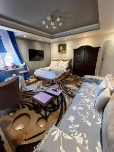 a bedroom with a bed and a couch and a tv at Warmiński Apartament in Biskupiec