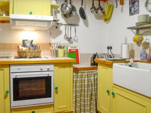 a kitchen with yellow cabinets and a sink at 5 Church Square in Rigg