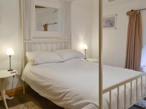 a bedroom with a white bed and a mirror at 5 Church Square in Rigg