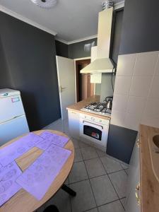 a small kitchen with a table and a stove at Warmiński Apartament in Biskupiec