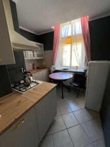 a kitchen with a stove and a table and a window at Warmiński Apartament in Biskupiec