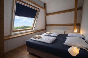 a bedroom with two beds and a window at Ballumerhoeve Fleuri lodge in Ballum