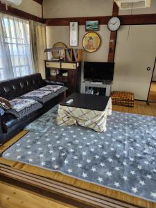 a living room with a couch and a large rug at 玉の浦sea in Nachikatsuura