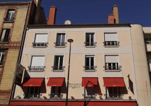 a building with red awnings on the side of it at Alma Hotel in Courbevoie