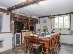 a dining room with a wooden table and chairs at Westacombe Farmhouse in Exeter