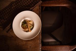 a plate of food on a wooden table at Wohlfühlhotel Hubertushof am Arlberg - Ski-In & Ski-Out - Sky Pool in Stuben am Arlberg +31 photos