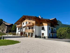 a large white building with a wooden roof at Appartamento Rododendro in Andalo