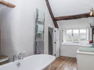 a white bathroom with a tub and a sink at Westacombe Farmhouse in Exeter +64 photos