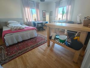 a bedroom with a bed and a table and a dining room at Rymlig 2-rumssvit nära Centralstationen - Anna Josefinas Stay in Umeå