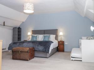 a bedroom with a bed with blue pillows and a suitcase at Westacombe Farmhouse in Exeter