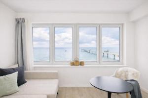 a living room with a window with a view of the ocean at Ostsee Suite 4 - Strandperle in Niendorf