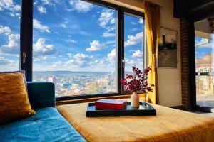 a living room with a couch and a large window at Studio54 Stunning View plus Free Parking in Veliko Tŭrnovo