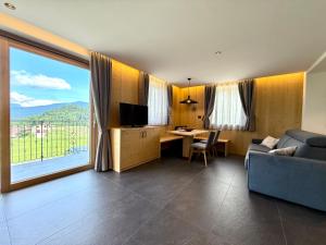 a living room with a couch and a desk with a television at Appartamento Erica in Andalo