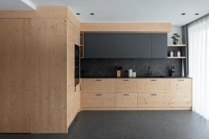 a kitchen with wooden cabinets and a large television at Appartamento Erica in Andalo