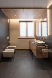a bathroom with two sinks and two toilets at Appartamento Erica in Andalo +56 photos