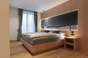 a bedroom with a bed with a large headboard at Appartamento Erica in Andalo