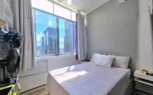 a bedroom with a bed and a large window at Studio no Largo da Carioca - Rio de Janeiro in Rio de Janeiro