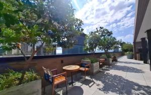 a patio with tables and chairs and trees at Studio no Largo da Carioca - Rio de Janeiro in Rio de Janeiro