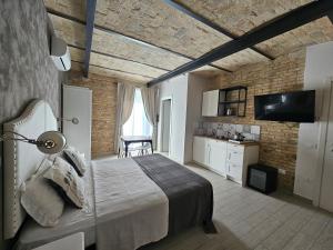 a bedroom with a large bed and a brick wall at Al Faro Bianco B&B e Residence con parcheggio in Vasto