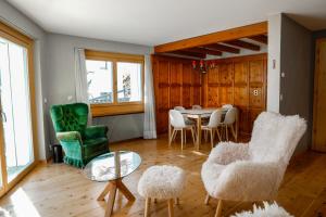 a living room with a table and chairs at Chesa Chavriol - Samedan in Samedan