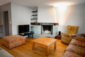a living room with a fireplace and a couch at Chesa Chavriol - Samedan in Samedan