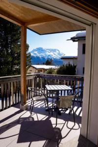 a patio with a table and chairs on a balcony at Chesa Chavriol - Samedan in Samedan