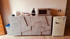 a small kitchen with a microwave and a refrigerator at Casale SoleLuna - Bagno condiviso in Sorrezzana