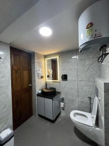 a bathroom with a toilet and a sink at Luxury Villa in Falnir in Mangalore +17 photos