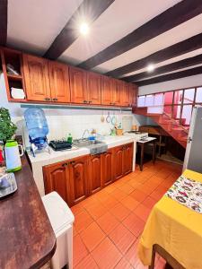 a kitchen with wooden cabinets and a counter top at Hospedería Villa Lucía in Villa de Leyva