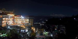 a view of a city at night with buildings at Tenzin's Inn in Jālāpahār +14 photos