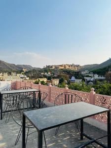 two tables and chairs on a balcony with a view at Hotel Panna Haveli in Jaipur