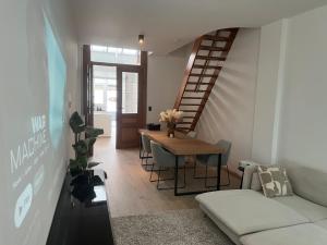 a living room with a table and a staircase at Holiday house with private jaccuzi - Leuven city center in Leuven