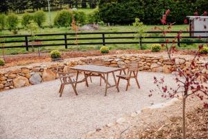 a wooden picnic table and chairs in a garden at Exclusive luxury tiny home in an idyllic setting in Glenquarry