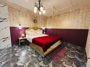 a bedroom with a bed with a red comforter at Velouria Homestay in Guwahati