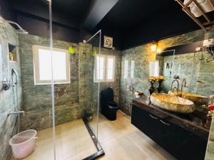 a bathroom with a large sink and a shower at Velouria Homestay in Guwahati