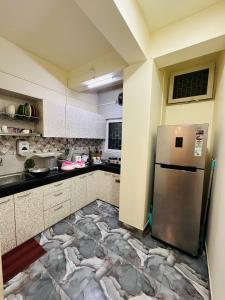 a kitchen with a refrigerator in the middle of it at Velouria Homestay in Guwahati