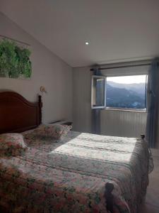 a bedroom with a bed with a window in it at Mélita Guesthouse in Braga