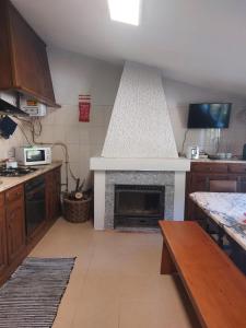 a kitchen with a fireplace in the middle of it at Mélita Guesthouse in Braga