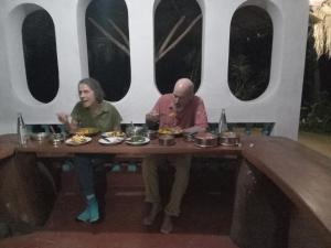 a man and a woman sitting at a table with food at Galoya Mahagedara in Inginiyagala